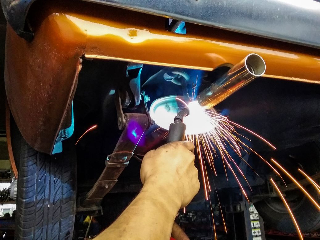 closeup-of-blue-collar-worker-welding-classic-car-2023-11-27-05-20-53-utc